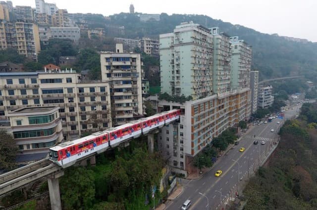 เผยภาพน่าตื่นตา รถไฟฟ้าเมืองจีนวิ่งทะลุแฟลตสูง 19 ชั้น หลังสร้างรางตามปกติไม่ได้